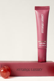 Strange Luxury lip balm and packaging on a white background.