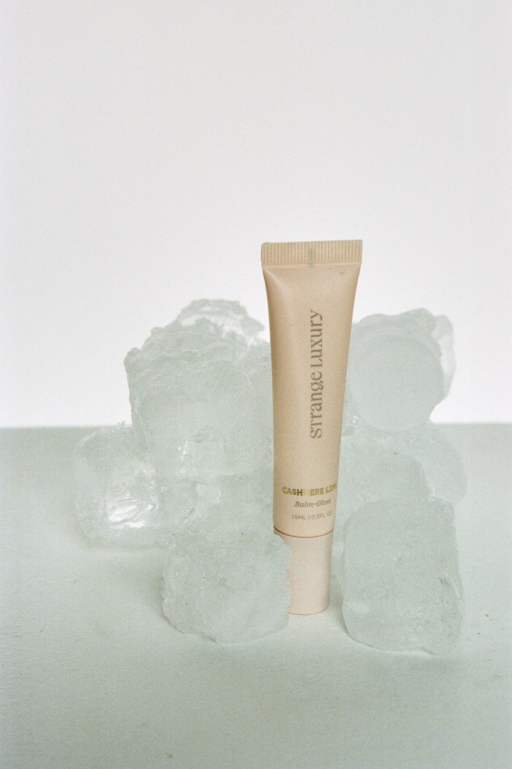 Skincare tube on a textured white surface with a light gray background.