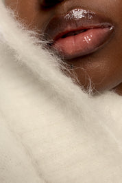 Close-up of a person's lips with a white cashmere background.