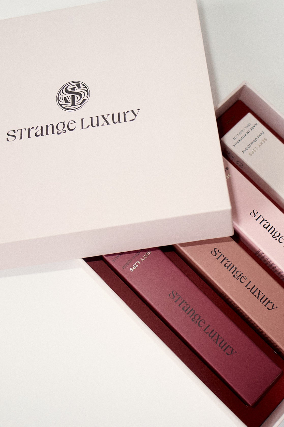 Strange Luxury lipsticks in a box on a light background.
