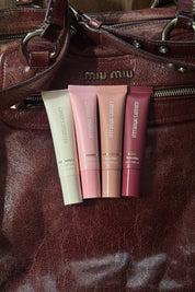 Lipstick tubes on a brown leather surface.