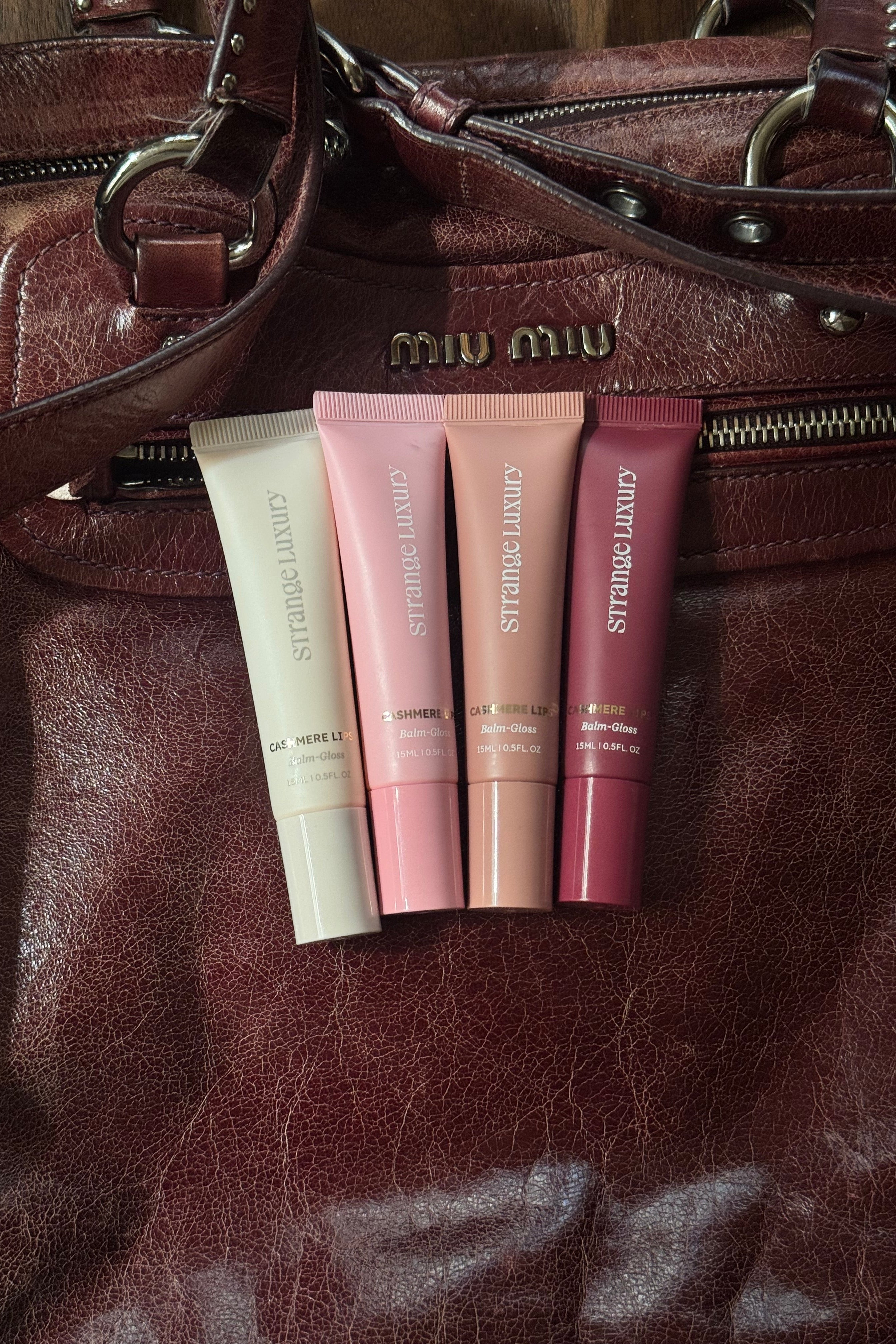 Lipstick tubes on a brown leather surface.