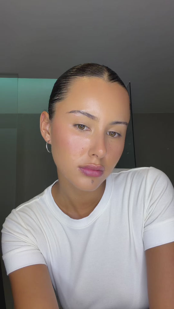 Model applying Cashmere Lips in bathroom.